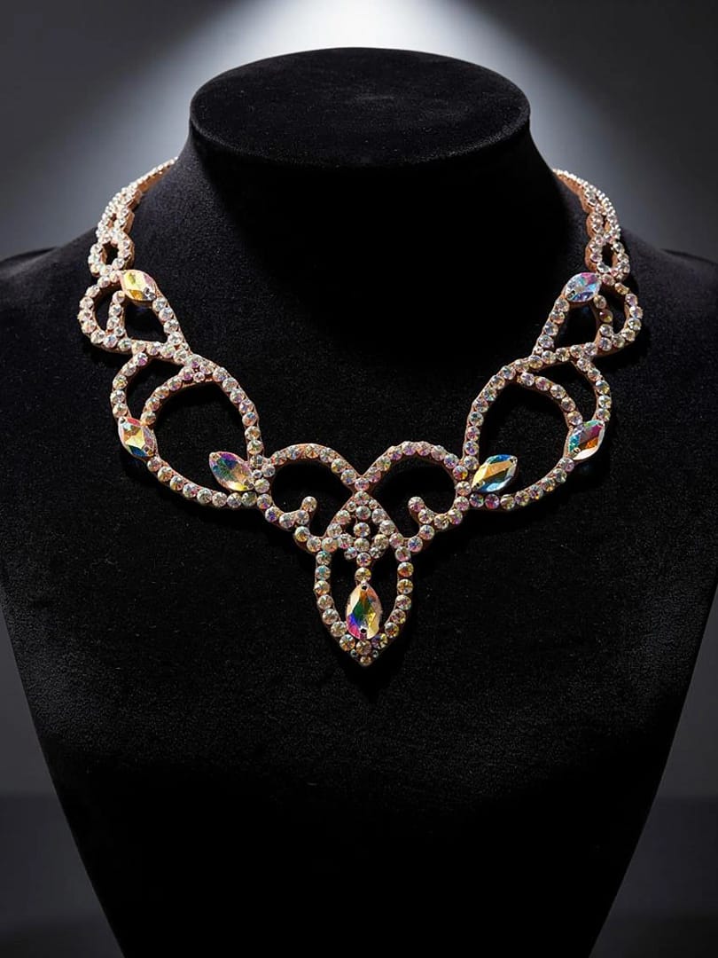 Ballroom competition necklace displayed on black bust, highlighting symmetrical crystal scroll design and center drop